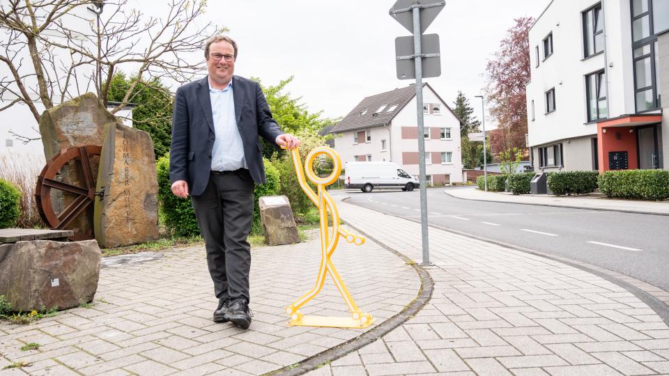 Minister steht auf einer Gehweg in Lohmar